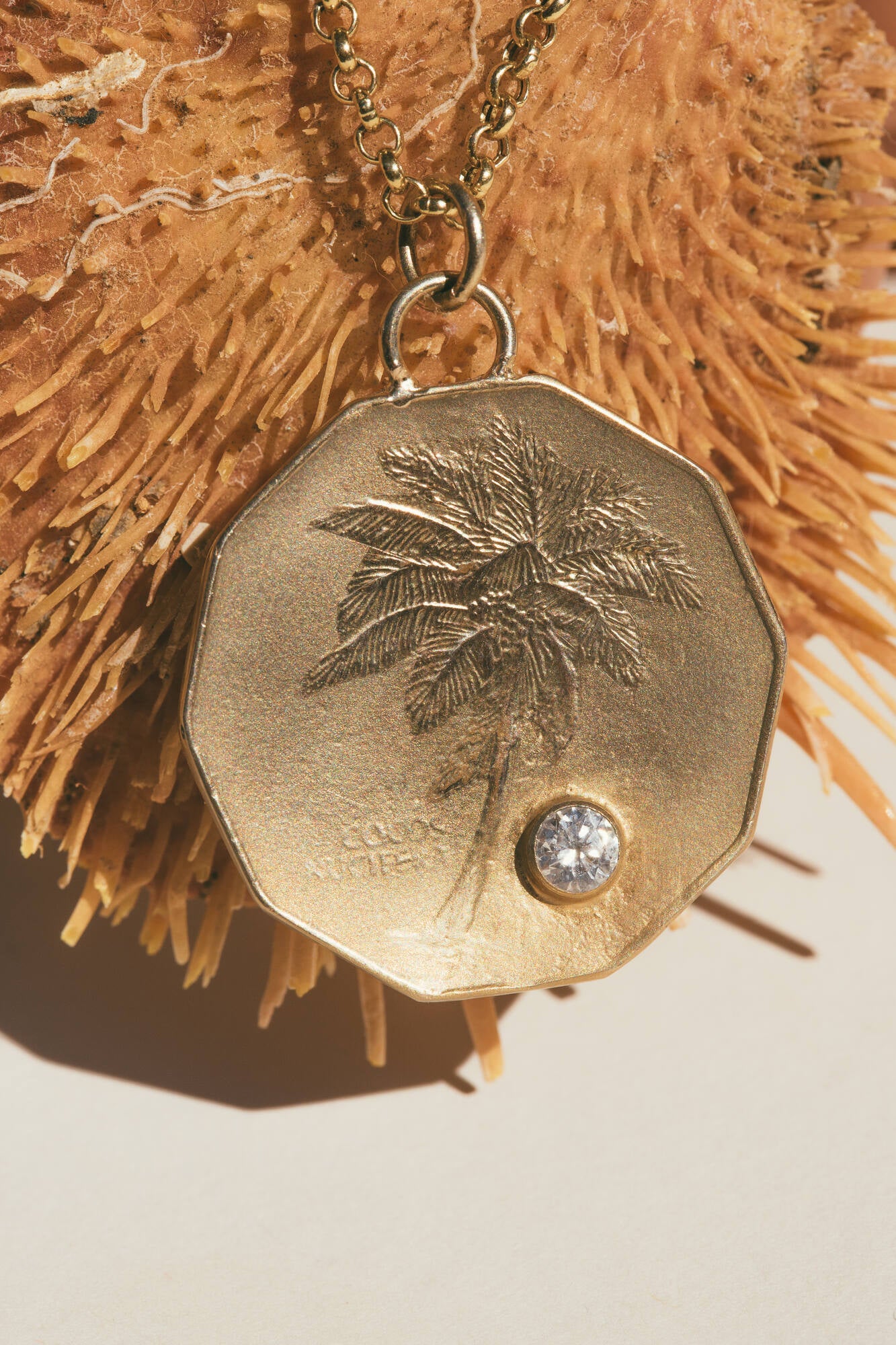 A CLOSE UP OF THE GOLD PALM TREE & DIAMOND COCONUT CHARM
