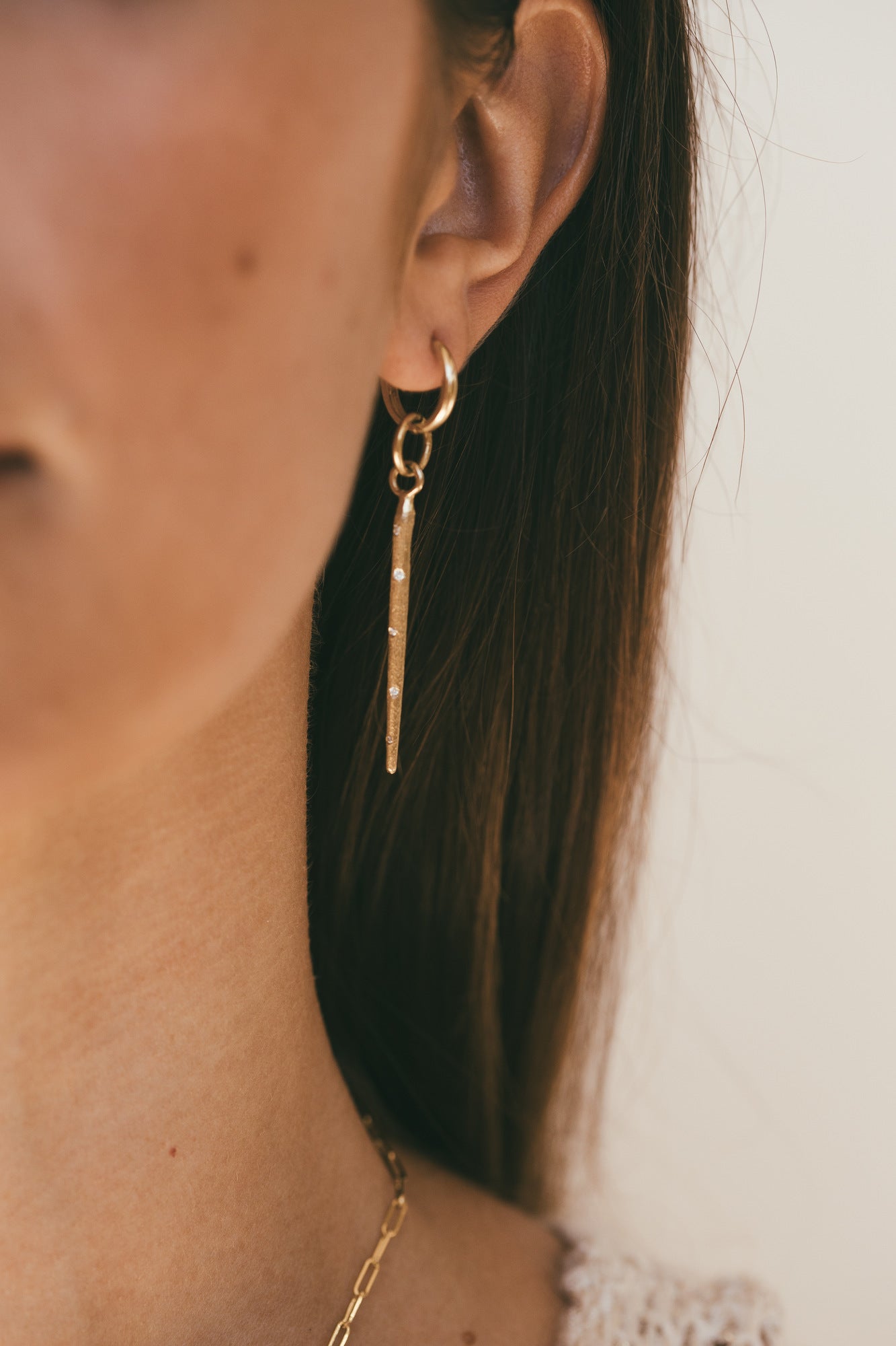 close up image of a Model looking to the side with gold sea urchin earrings