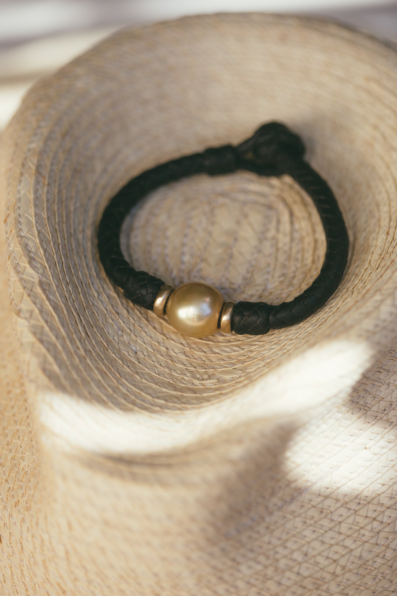 A CLOSE UP OF THE TAHA’A 14K GOLD BRACELET WITH GOLDEN SOUTH SEA PEARL