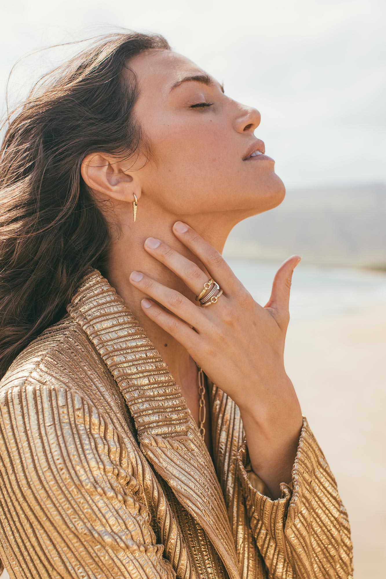 Model wearing poker earrings on the beach