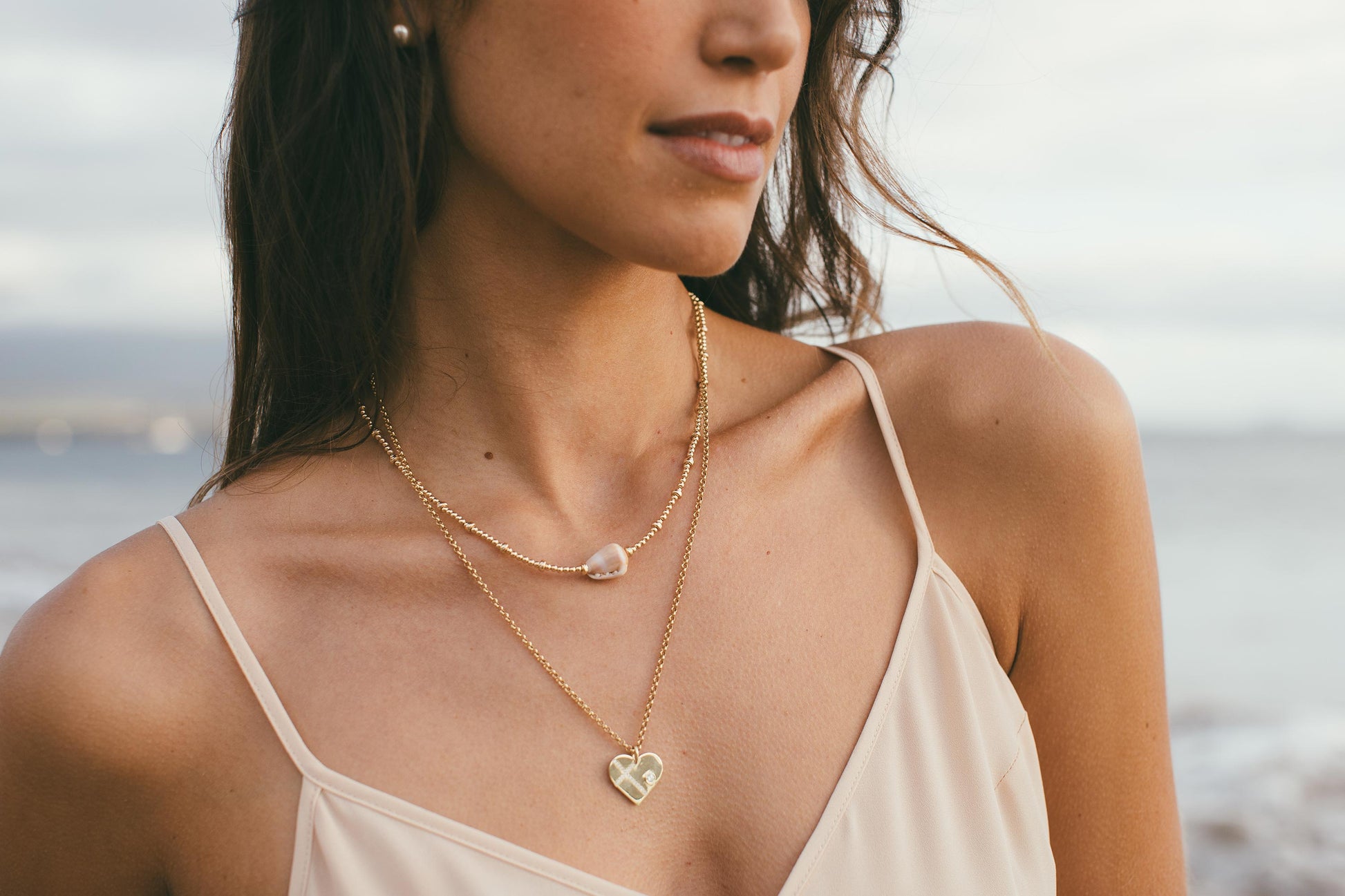 Model on beach wearing heart charm